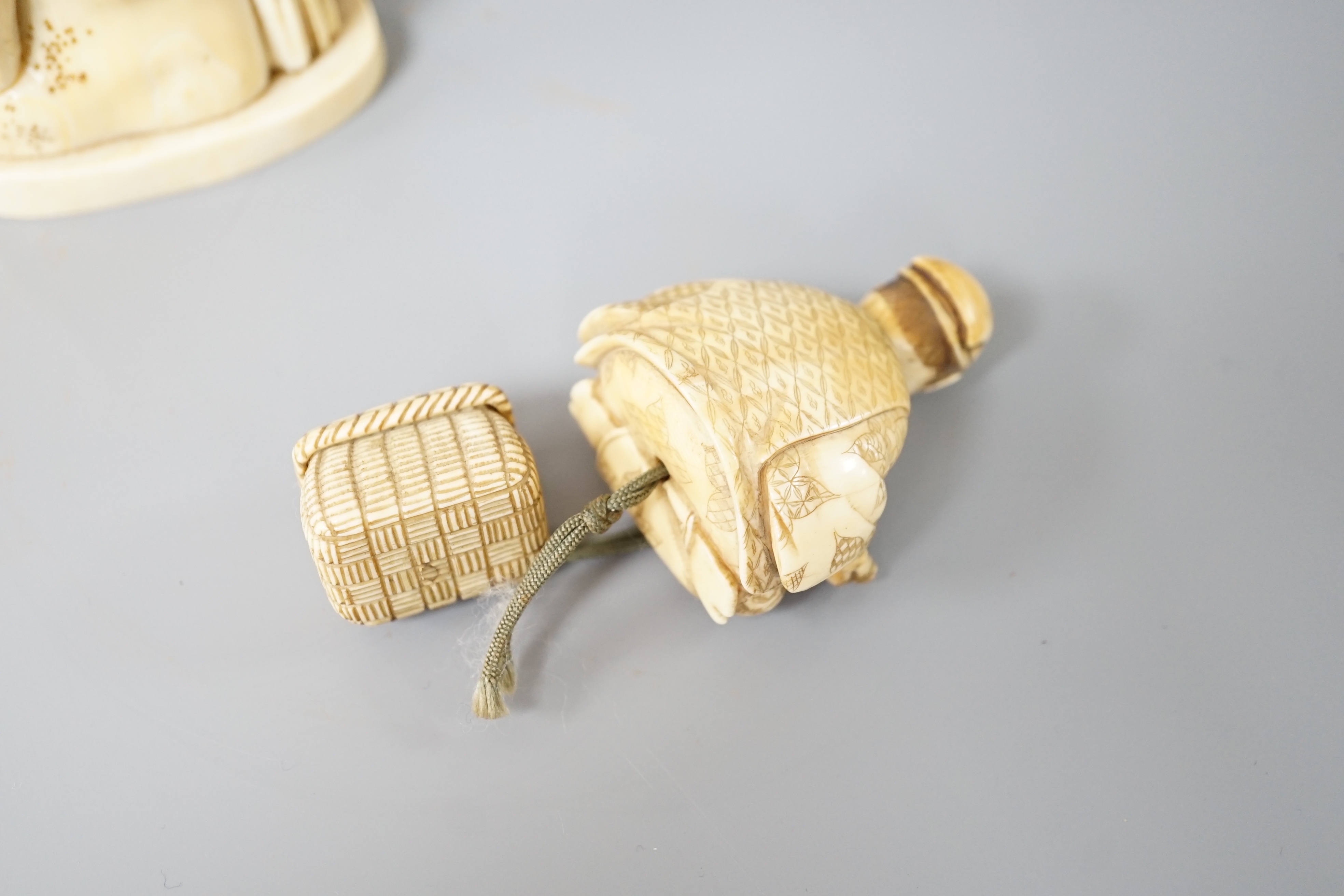 A 19th century Japanese marine ivory okimono of a bearded man and child together with a similar ivory okimono of a mask seller. Tallest 21cm